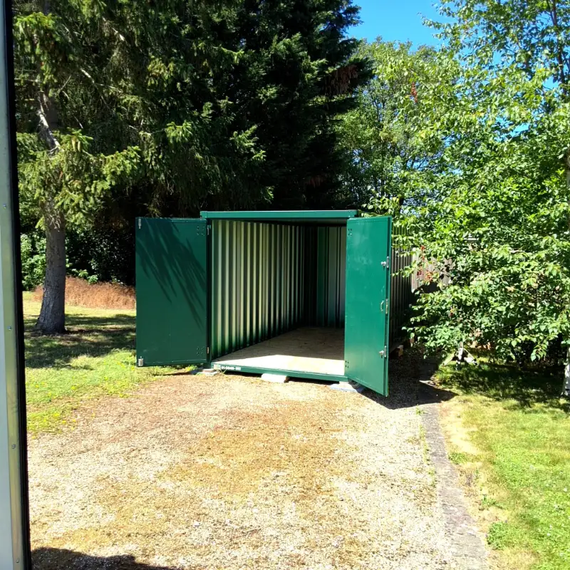 Open door of a Door To Store unit in a garden